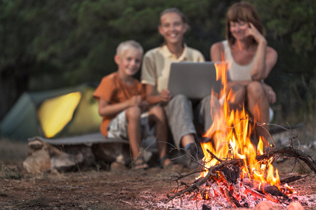 Blurred silhouette of family with laptop at the campingの写真素材