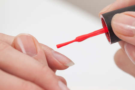 Manicure specialist painting clients nails red at the nail salonの写真素材