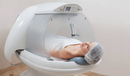 Woman lying in the capsule at the spa salonの写真素材