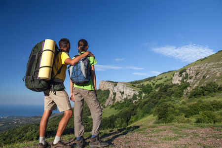 Two hikers looking at the mountain. Backpackers research a way at the mountainsの写真素材
