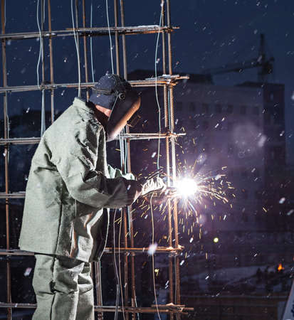 Welding and bright sparks on steel constructions. Hard job. Night timeの写真素材