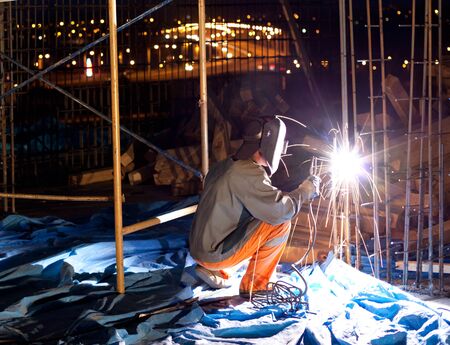 Welding and bright sparks on steel constructions. Hard job. Night timeの写真素材