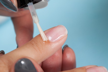 Manicure specialist painting clients nails red at the nail salonの写真素材