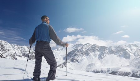Climber looking at a snowy mountain landscape in a sunny winter day.の写真素材