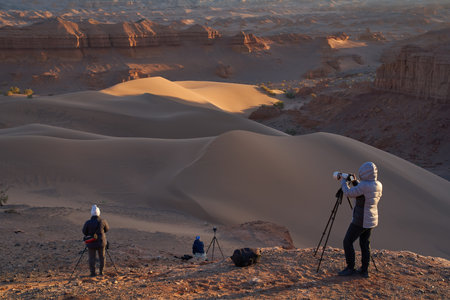 Landscape Photographers Capturing Dunes at Golden Hour in Desert Landscapeの写真素材