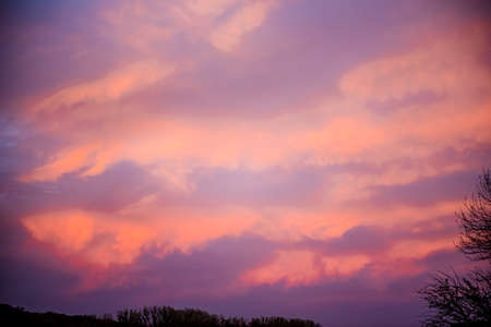 Dramatic sunrise, sunset pink purple sky with clouds background texture.の写真素材