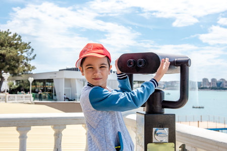 Little boy looking into tourist telescope eyepiece. Travel tourist destination landscape magnificationの写真素材