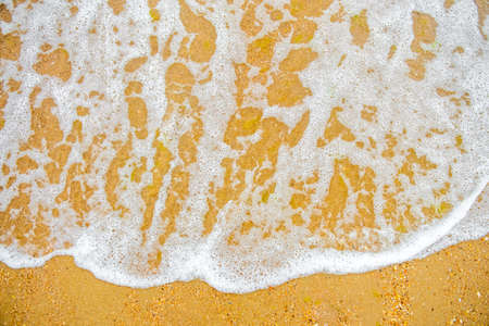 White wave on empty yellow sandy beach, summer or tropical climate background, nature background, daylight outdoorsの写真素材