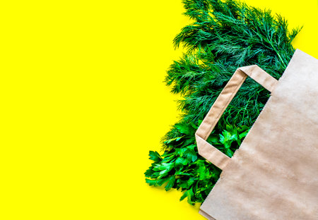 Eco bag with groceries on a yellow background. Juicy greens and broccoliの写真素材