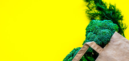 Eco bag with groceries on a yellow background. Juicy greens and broccoliの写真素材