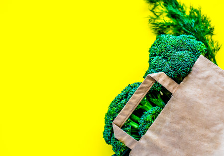 Eco bag with groceries on a yellow background. Juicy greens and broccoliの写真素材