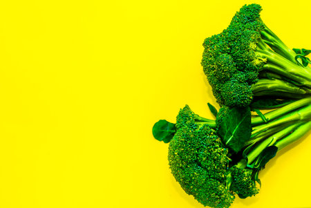 Juicy greens and broccoli on a yellow background. place for inscriptionの写真素材