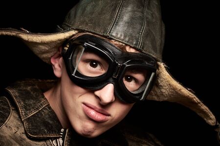 Young man with hat and goggles vintage look on black backgroundの写真素材
