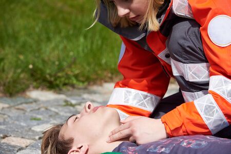 Professional paramedic giving unconscious young man first aidの写真素材