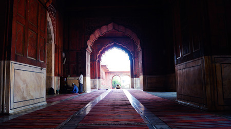 Jama Masjid in details. New Delhi. The prayer hall in the mosque. Muslims during prayer. Carved arch on the background.のeditorial素材