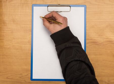 Man fills the empty blank on a background of a wooden table