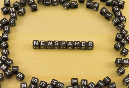 The word newspaper on wood backgroundの写真素材
