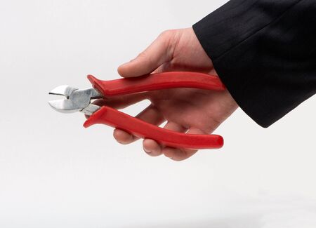 Nippers in the hands of a businessman on a white backgroundの写真素材