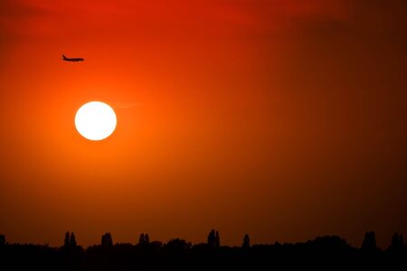 Silhouette of a plane at sunsetの写真素材