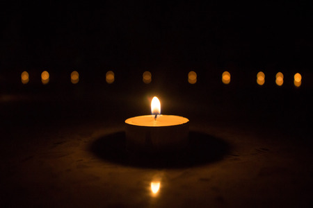 Shining candle with dark and bokeh backgroundの写真素材