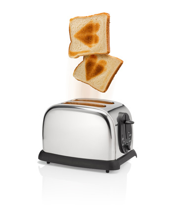 Freshly roasted bread pops out from a toaster with heart shaped burn marks.