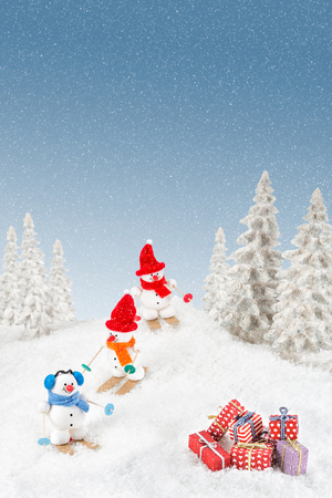 Snowmen are out skiing and becomes very happy when they find christmas gifts in the snow.の写真素材