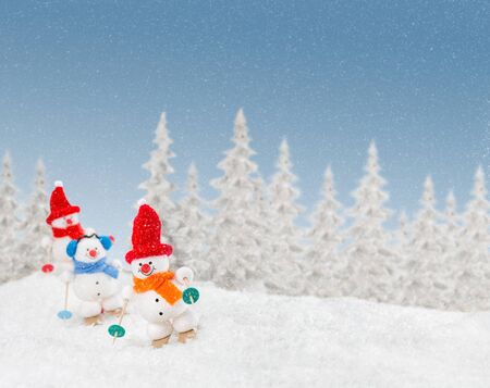 Snowmen out skiing in the snow during snow stormの写真素材