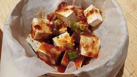 Japanese Tofu cheese in sweet sour sauce sprinkled with green onions. Tofu in paper.の写真素材