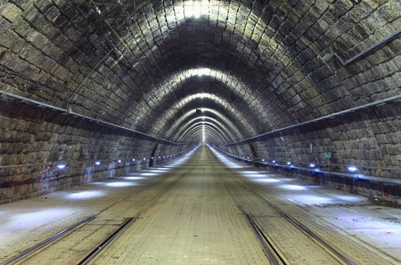 A train disappearing into a tunnel at nightの写真素材