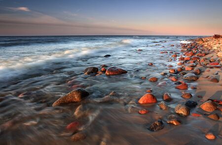 Beatiful sunset on the stones beachの写真素材