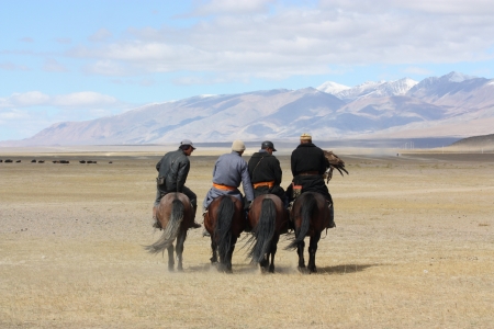 Mongolians horsemen in traditional clothing with golden eagles during the festival of name  The Golden Eagle Festival  July 25, 2011, Mongolia - desertの写真素材