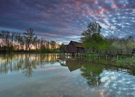 Summer landscape with river and watermill with dramatic sunset の写真素材