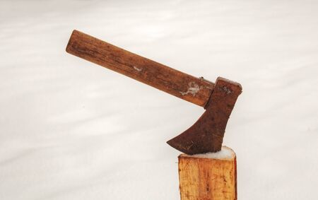 Axe in a log on winterの写真素材