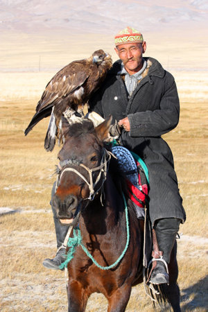 MONGOLIA - 25 JULY  The senior Mongolian  - horseman in traditional clothing with golden eagle during the festival of name  The Golden Eagle Festival  July 25, 2011, Mongolia - desertのeditorial素材
