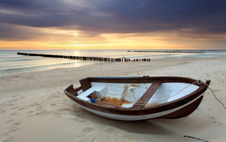 Boat on beautiful beach in sunriseの写真素材