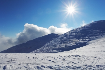 Winter mountain landscape with sunの写真素材
