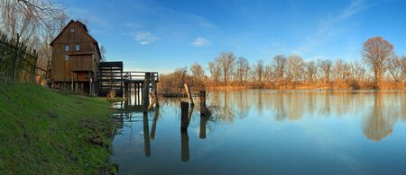 River reflection with watermill and treeの写真素材