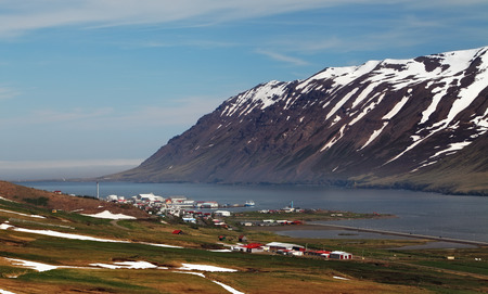 Mountains, fjord, hay bales on the meadow in background.の写真素材