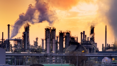 Smokestack in factory with yellow sky and clouds 