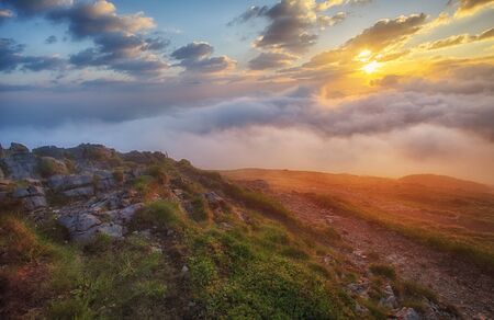 Mountain mist at sunrise with cloudsの写真素材