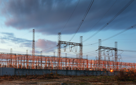 electricity transmission pylon silhouetted against blue sky at duskの写真素材