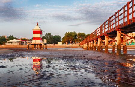 Italy beach - Lignano Sabbiadoro Lighthouse with beach at sunriseの写真素材