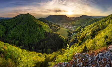 Green landscape with village, mountain and rocks at sunset, Natureの写真素材