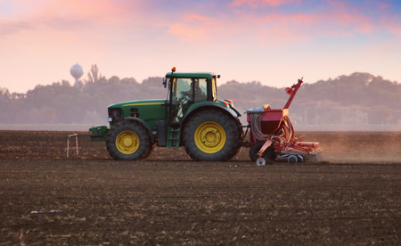 Tractor on field at sunsetのeditorial素材