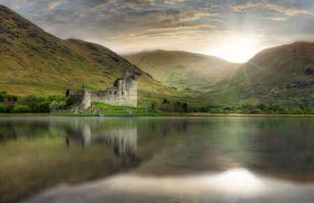Kilchurn Castle with reflection in water at dramatic sunset, Nice Scotland landscapeの写真素材