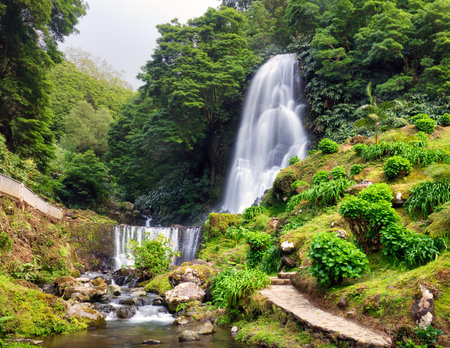 Waterfall at Ribeira dos CaldeirÃµes in Nordeste with tourists, Sao Miguel island in the Azores.の写真素材