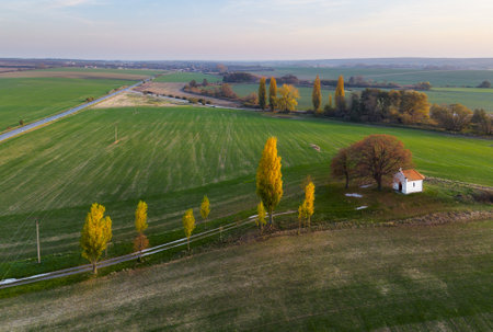 Landscape on fields at sunset with chapel, aerial viewの写真素材