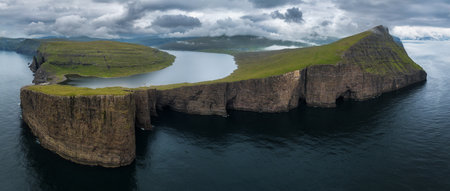 Drone Panorama of Sorvagsvatn lake and cliffs of Traelanipa on Vagar island in sunset, Faroe Islands mountain and ocean landscapeの写真素材