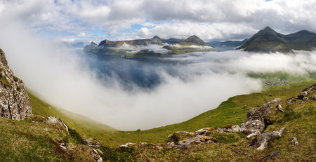 Mountain landscape view over clouds in Fareo islands.の写真素材