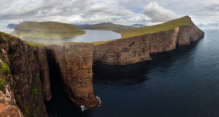 Faroe Islands landscape- Hike to the Traelanipa Slave Cliff near Leitisvatn Lake with steep drops into the ocean, Denmark.の写真素材